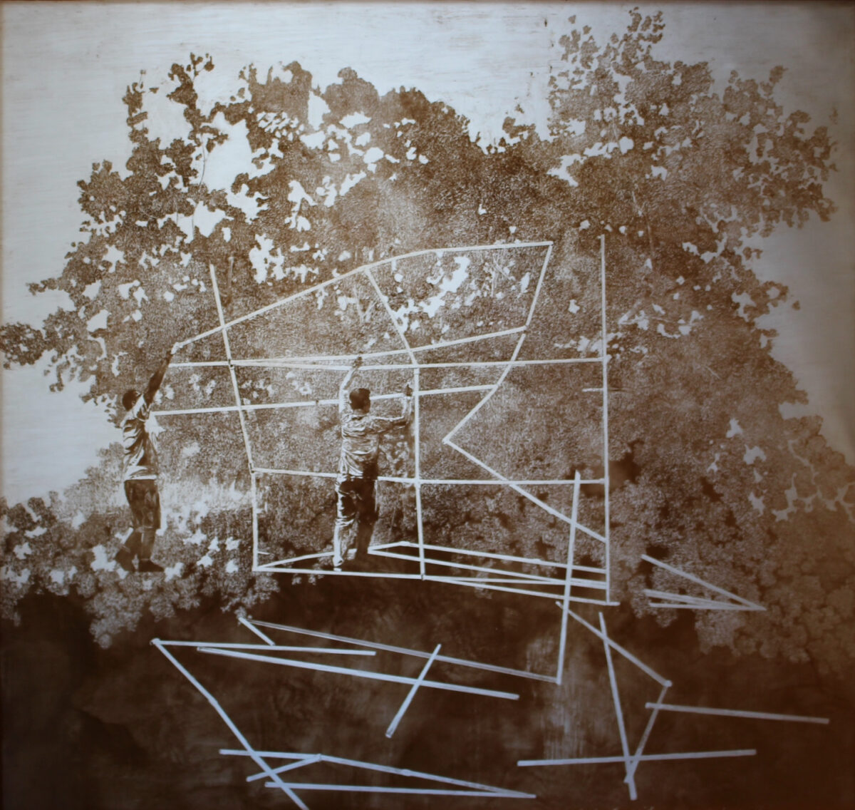 A mixed media drawing of acrylic medium and gold pigment on plexi-glass depicts two male figures with arms raised above their heads as if holding a long pieces of wood together. Instead their hands are holding white lines. A series of white lines or bands intersects in the center of the composition, making an abstracted, building like construction. In the background is a textural wash, similar to peeling paint with a water color like effect in the bottom third of the composition. The drawing has a monochromatic, sepia tone.