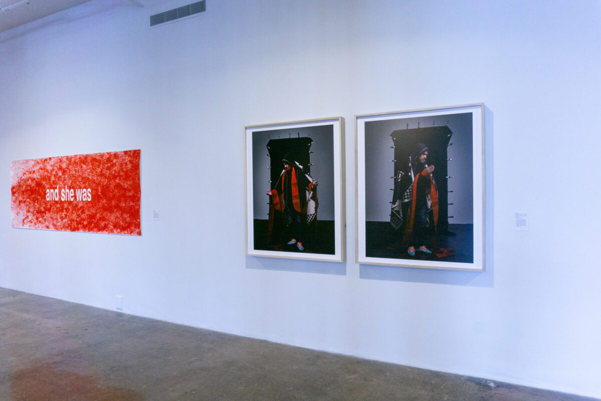 Image of three artworks on a wall, two of which feature a man dressed in modern clothing meant to allude to the Virgin Mary