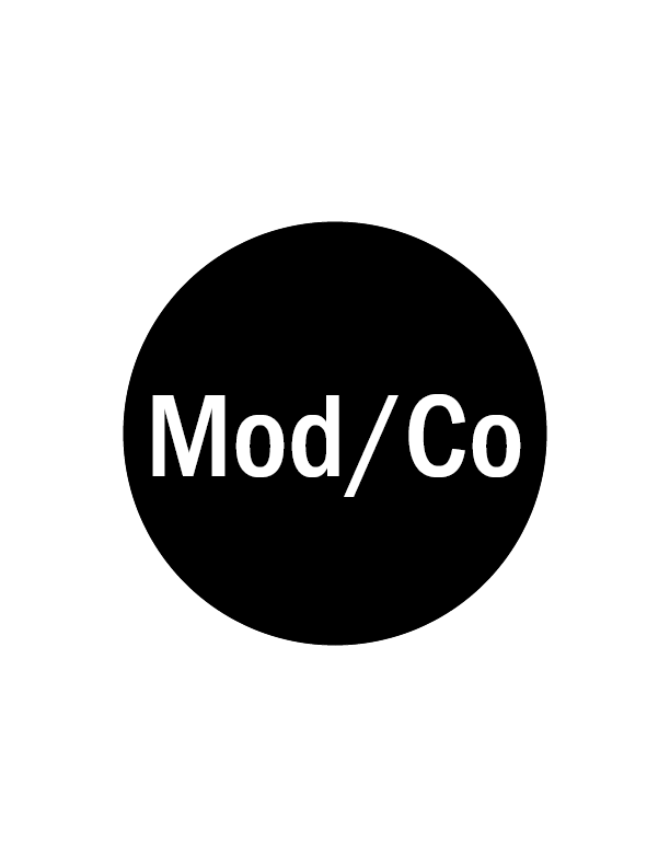 Black circle with white letters that say Mod/Co.